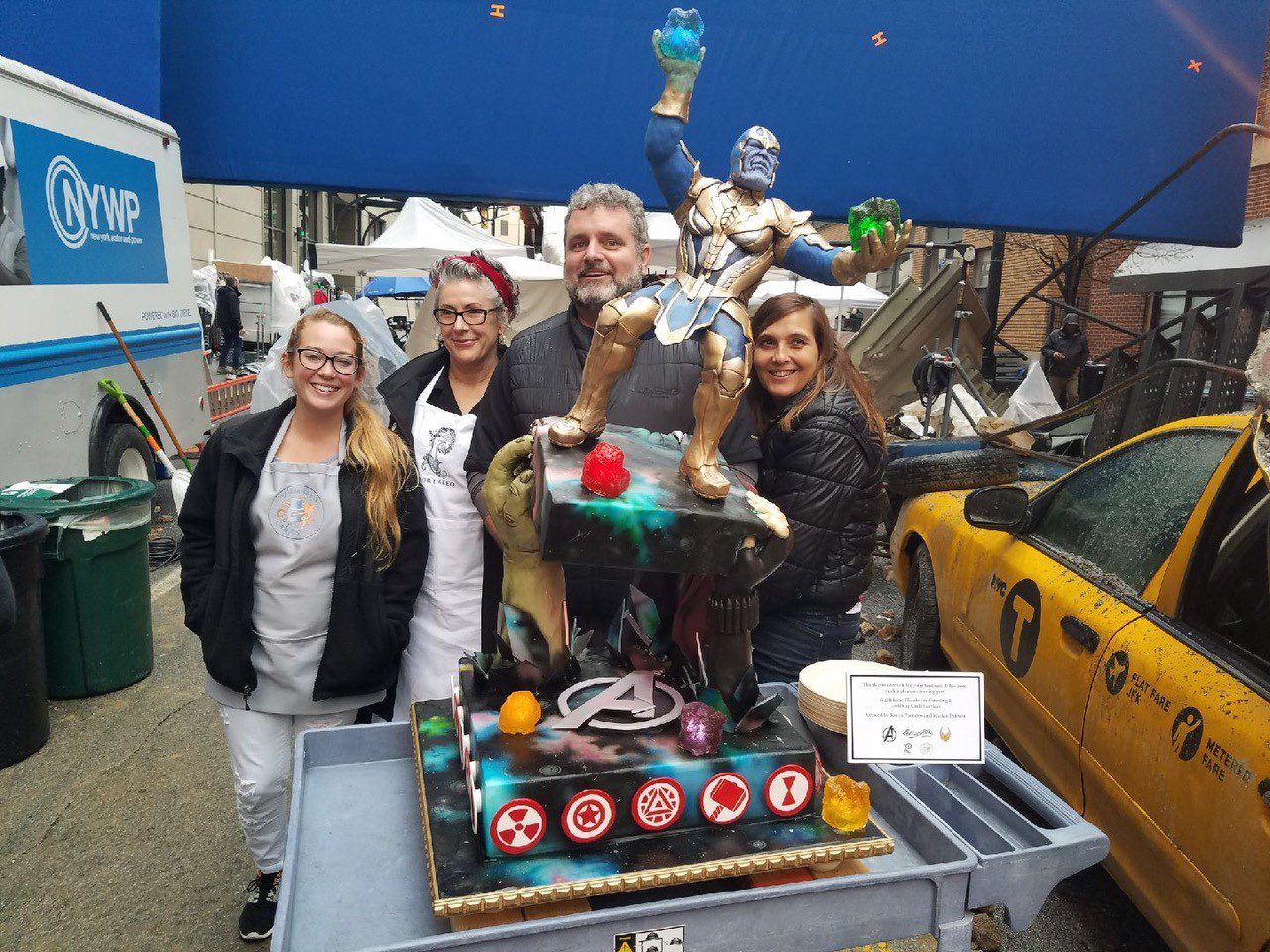 A group of people standing around a cake.