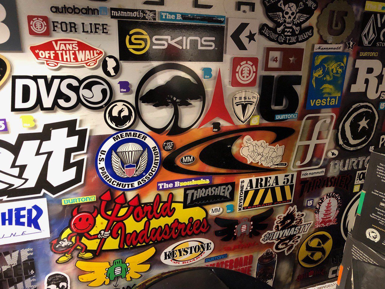 A wall covered in stickers and decals of various designs.