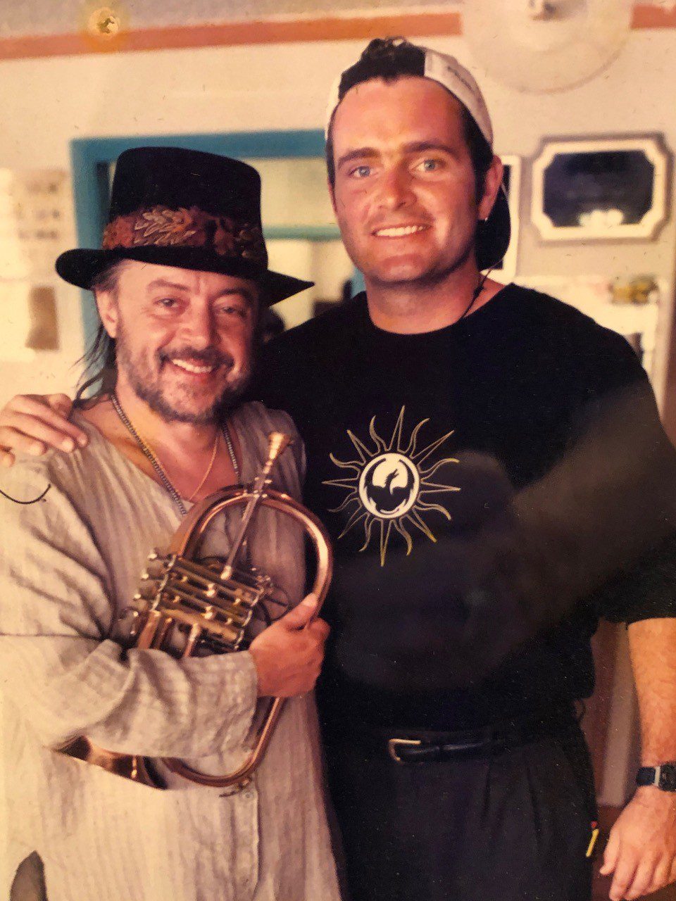 Two men posing for a picture with their instruments.