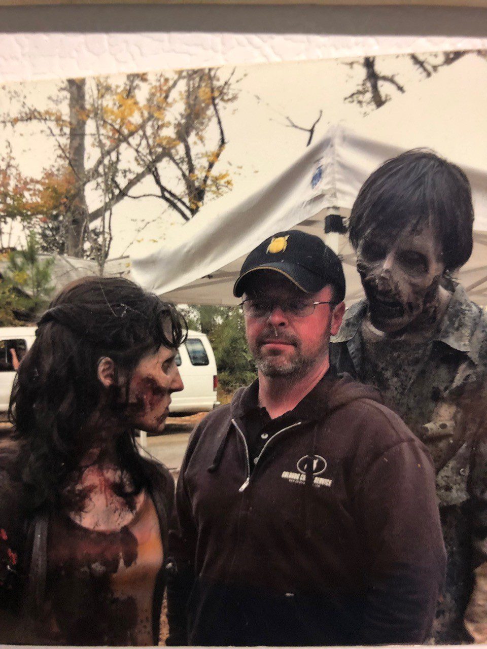 A man and two women dressed as zombies.